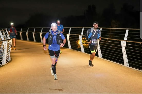 David running an ultramarathon at night on a bridge